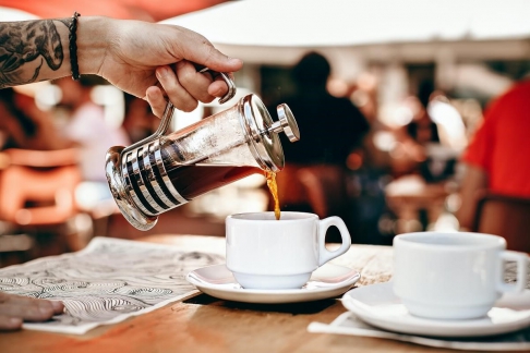 Kawa nalewana ze szklanego French Pressa do białej filiżanki